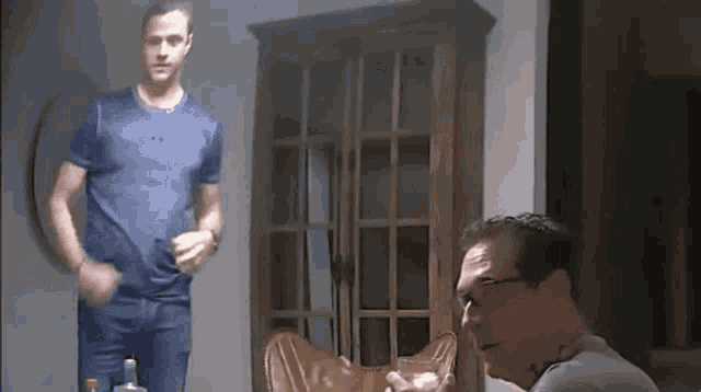 a man in a blue shirt stands next to another man