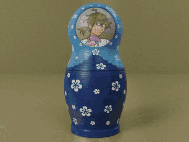 a blue green and orange nesting doll with a picture of a man on it