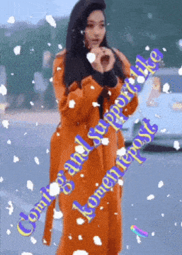 a woman in an orange coat making a heart with her hands and the words " coming and supporting " on the bottom