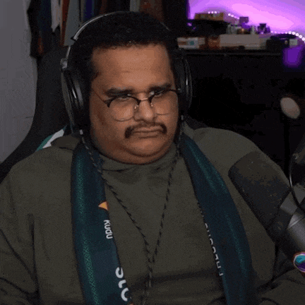 a man wearing headphones and a scarf with the word kudu on it is making a funny face
