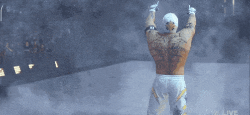 a man with a tattoo on his back is standing in front of a crowd with the word live on the bottom