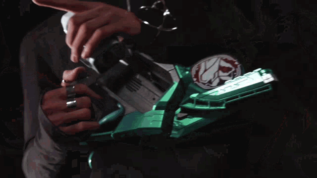 a person 's hand is reaching out towards a green item with the letter k on it