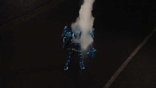 a person in a blue suit is surrounded by smoke in a dark room