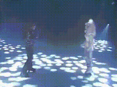 two people are dancing in a dark room with a lot of lights on the floor