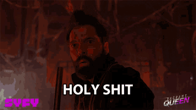 a man with a beard is holding a gun and says holy shit on the screen