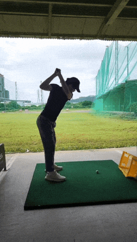a man swings a golf club at a golf ball