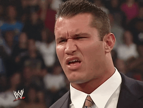 a man in a suit and tie with a w logo on his face