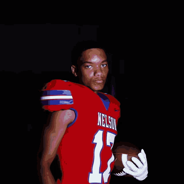 a football player with nelson on his jersey holds a football