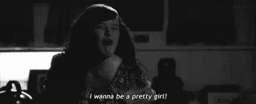 a black and white photo of a woman crying and saying i wanna be a pretty girl .
