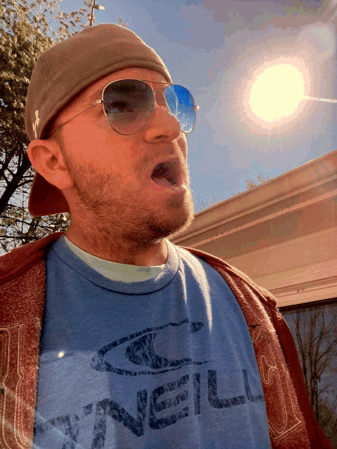 a man wearing sunglasses and a o'neill shirt