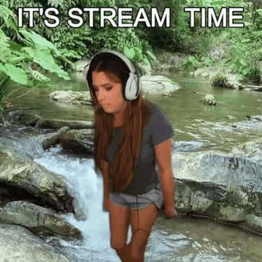a woman wearing headphones is standing in a stream with the words it 's stream time behind her