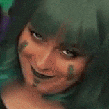 a close up of a woman 's face with green hair making a face .