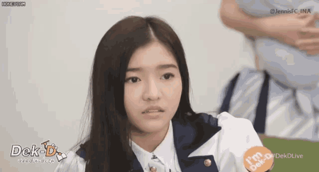 a girl with long hair is wearing a white shirt and a blue jacket