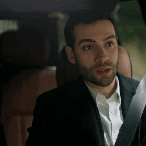 a man in a suit and white shirt is talking on a phone