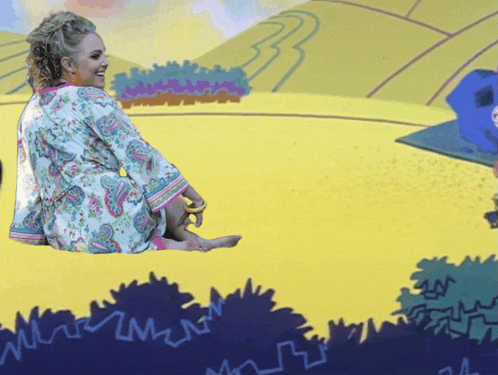 a woman in a paisley robe is sitting on a yellow field