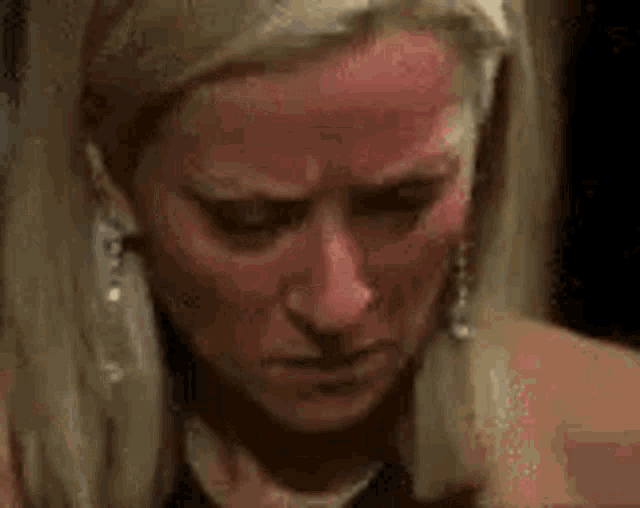 a close up of a woman 's face with a red spot on it .