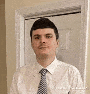 a man in a white shirt and tie is standing next to a door .