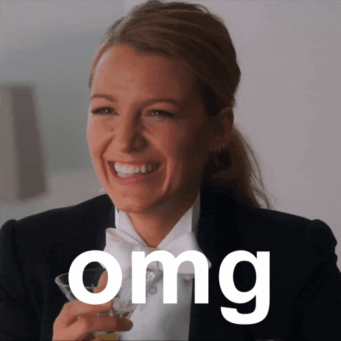 a woman in a tuxedo is smiling and holding a martini glass with the word omg above her