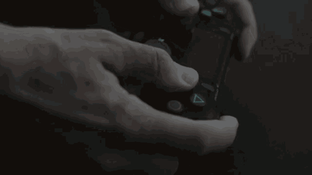 a person is holding a video game controller in their hand .
