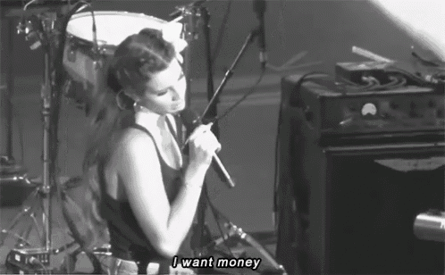 a woman singing into a microphone with the words " i want money " above her