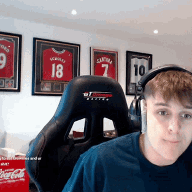 a man wearing headphones is sitting in a chair with a jersey on the wall behind him that says 18