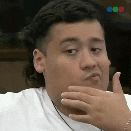 a man covering his mouth with his hand while making a face