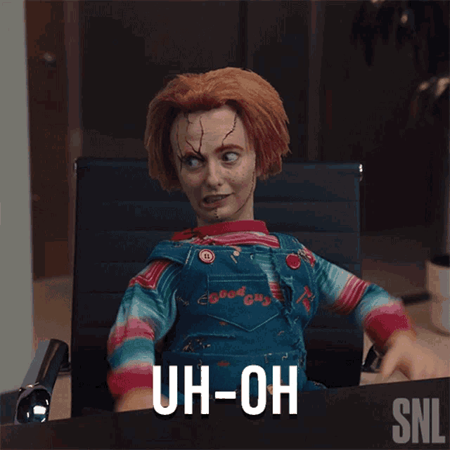 a chucky doll is sitting at a desk with the words uh-oh written on the bottom