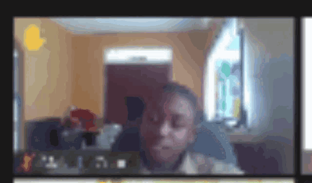 a blurry picture of a man sitting in front of a computer screen with the letters y and i on it