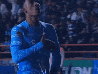 a soccer player wearing a blue jersey with telcel on the front
