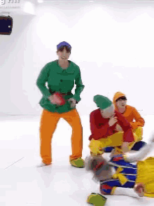 a group of people dressed as seven dwarfs are dancing on a white floor
