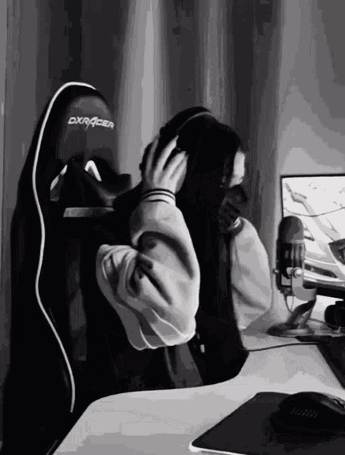 a black and white drawing of a person wearing headphones and a dxracer chair