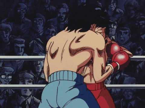 a man wearing red boxing gloves stands in a ring