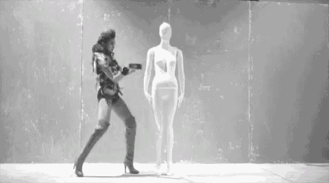 a woman standing next to a mannequin with a gun