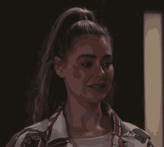 a woman with her hair in a ponytail is wearing a shirt with a horse print