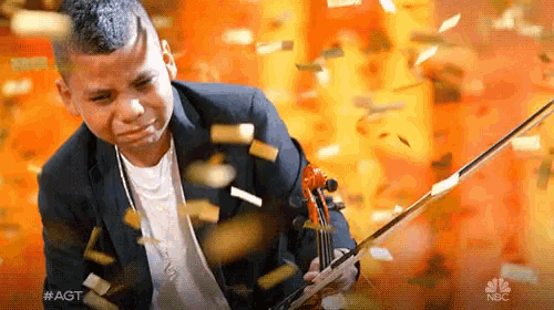 a young man playing a violin with confetti falling around him and the words #agt on the bottom