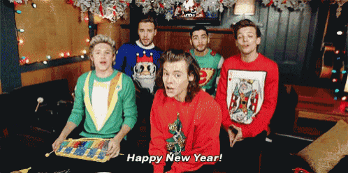 a group of young men wearing ugly christmas sweaters are sitting in a room and one of them says happy new year