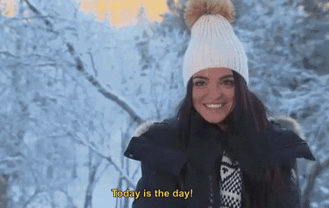 a woman wearing a white hat and a black jacket is smiling and says today is the day .