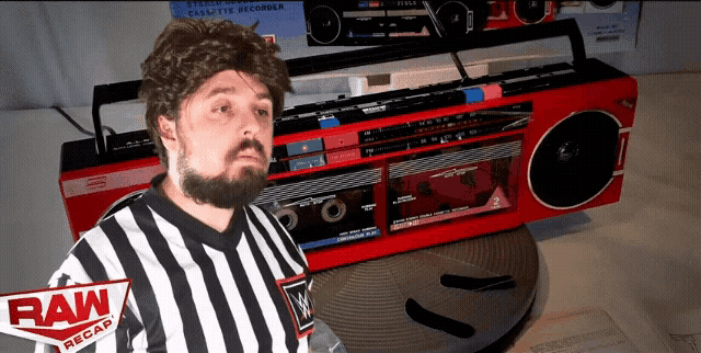 a man in a striped shirt is standing in front of a cassette recorder that says raw recap