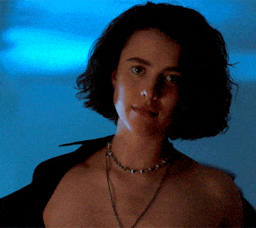 a woman without a shirt is wearing a choker