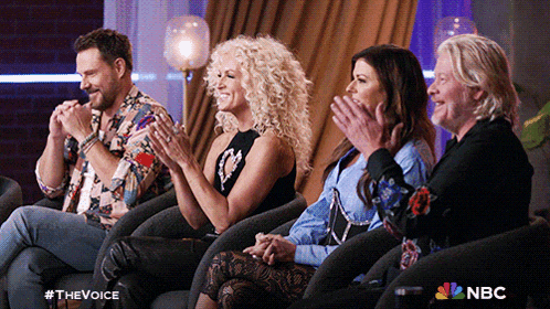 a group of people sitting in chairs applauding with a nbc logo in the corner
