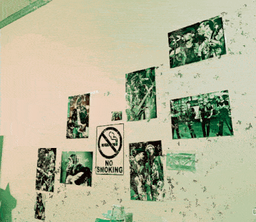 a no smoking sign is taped to a wall surrounded by pictures
