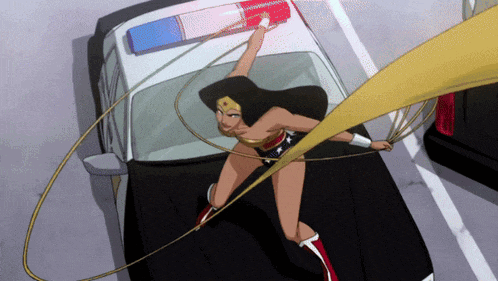 a woman in a wonder woman costume is standing on the hood of a police car