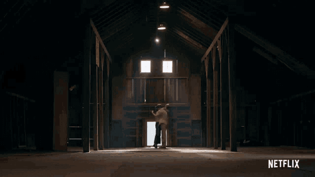a man is doing a handstand in an attic with a netflix logo behind him