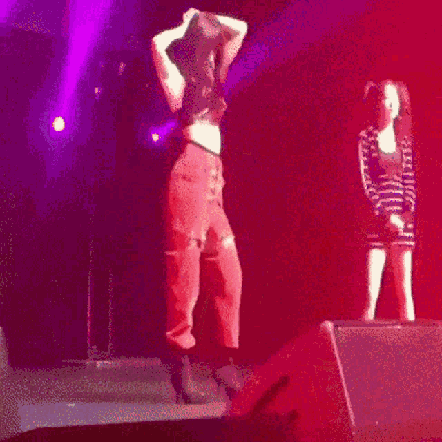a woman is dancing on a stage in front of a microphone .