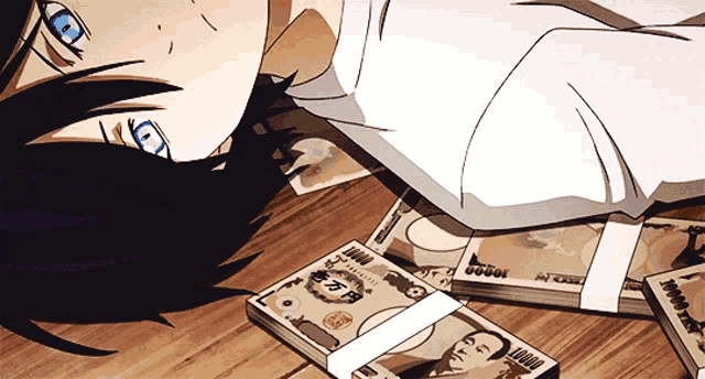 a person is laying on the floor with a stack of japanese money