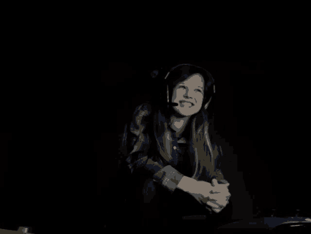 a young girl wearing headphones and a microphone smiles