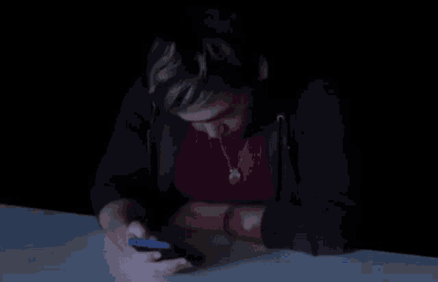 a man in a red shirt is sitting at a table with his arms outstretched