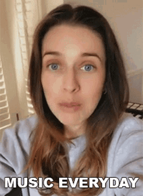 a woman is taking a selfie with the words music everyday above her