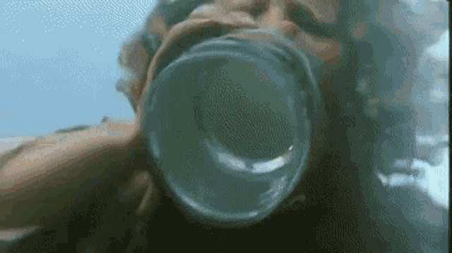 a woman is drinking water from a glass .