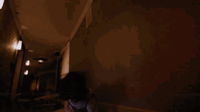 a person is standing in a hallway with a ceiling fan hanging from the ceiling .